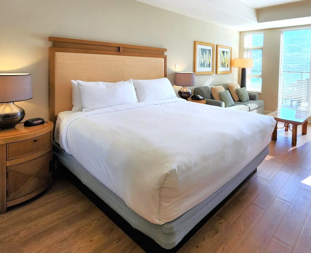 Cozy bed with a lake view from the window at Osoyoos Hotel, Watermark
