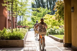 Couple bikes through Watermark Beach Resort in Osoyoos