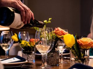 hand pouring white wine