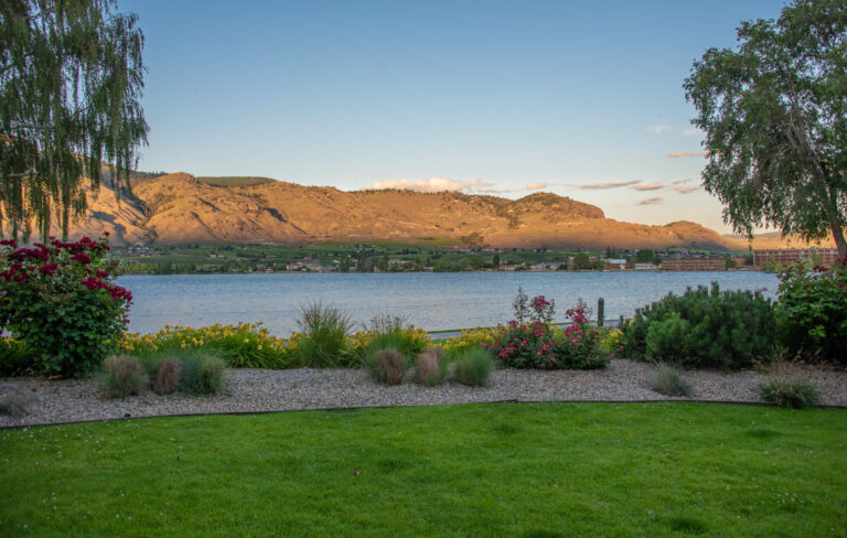 A desert bluff painted in sunlight sits above Osoyoos Lake.
