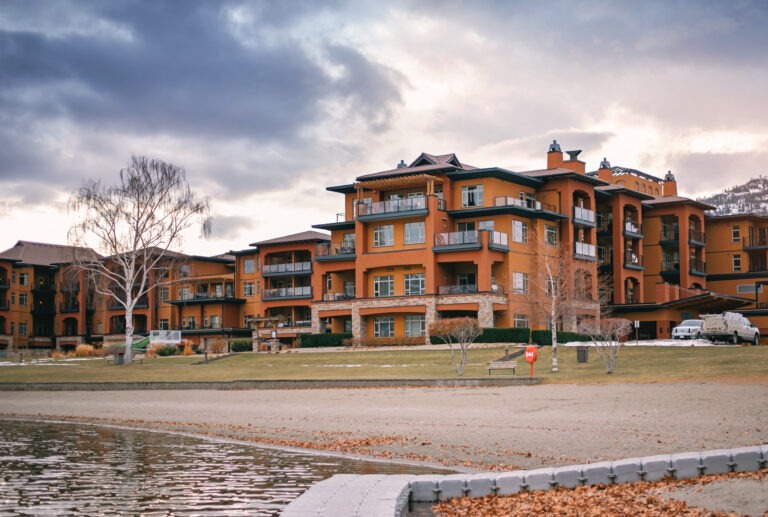 Watermark Beach Resort's terracotta building beside Osoyoos Lake on a snowy winter day with bare trees