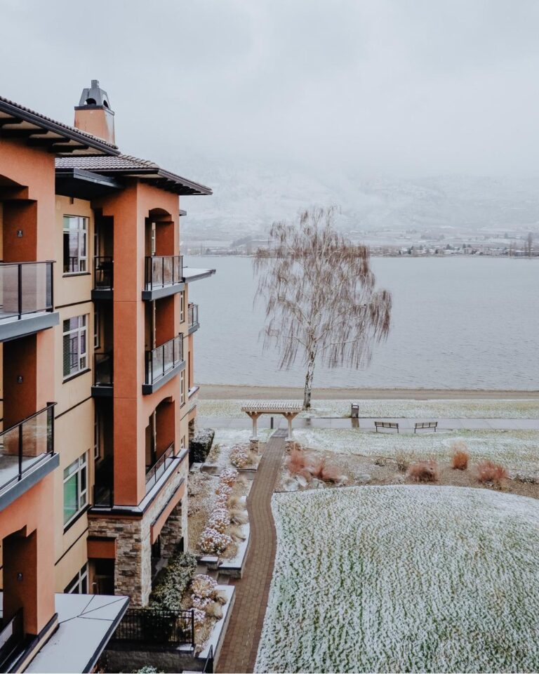 Watermark Beach Resort's terracotta building and lakeside grounds dusted with snow on a winter day in Osoyoos