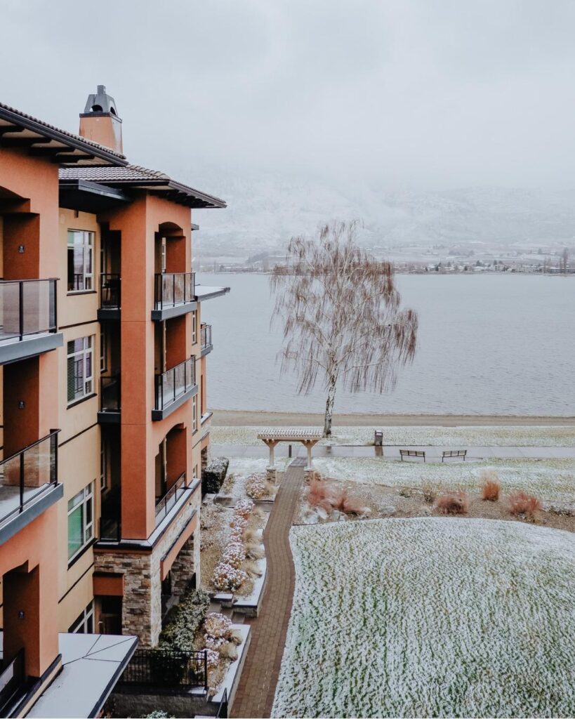 Watermark Beach Resort's terracotta building and lakeside grounds dusted with snow on a winter day in Osoyoos