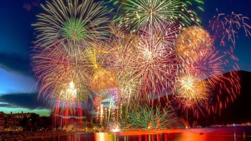 Colourful fireworks lighting up the sky over a lake during Canada Day celebrations in Osoyoos