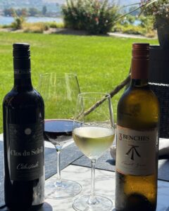 Clos du Soleil Célestiale and 3Benches Pinot Gris bottles with glasses on the 15 Park patio overlooking Osoyoos Lake