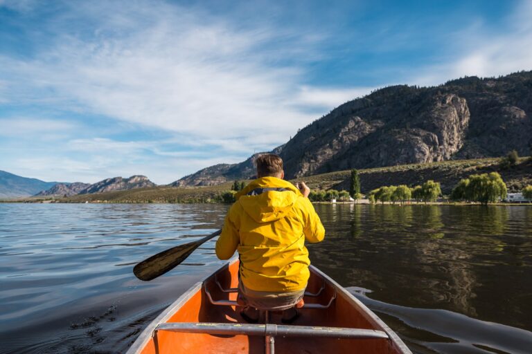 A kayaker gliding across calm water on Osoyoos Lake in early fall