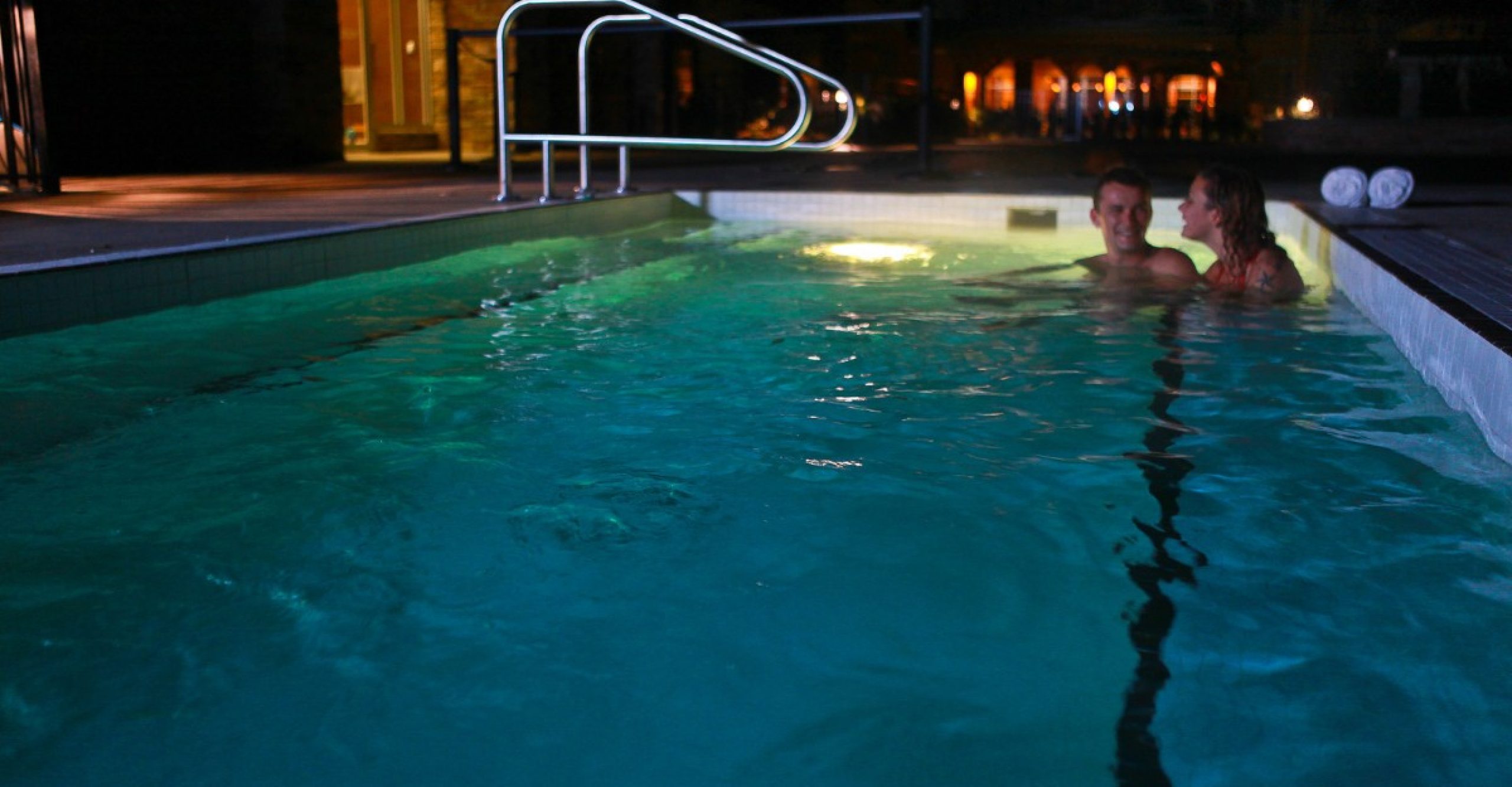 couple relaxing in hot tub at night